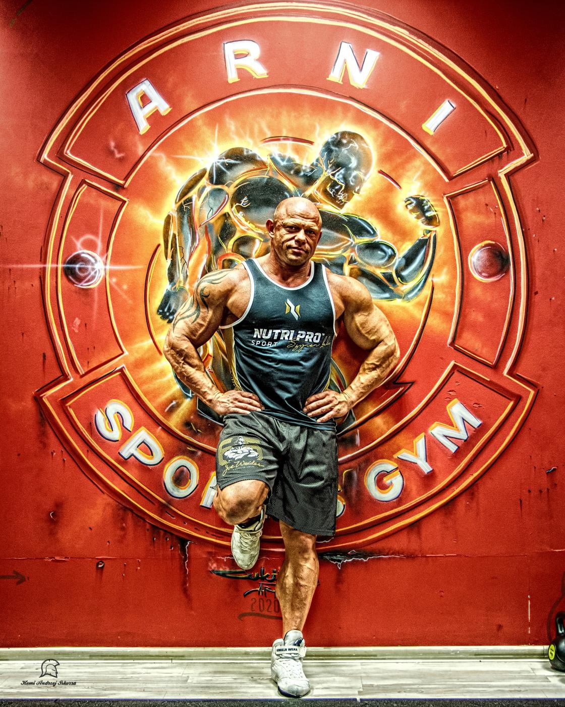 Arkadiusz „Arni” Demidowicz przed muralem klubu Arni Sport's Gym